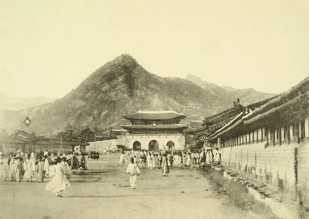 산을 배경으로 선 광화문과 그 앞길을 오가는 사람들이 담긴 흑백 사진
