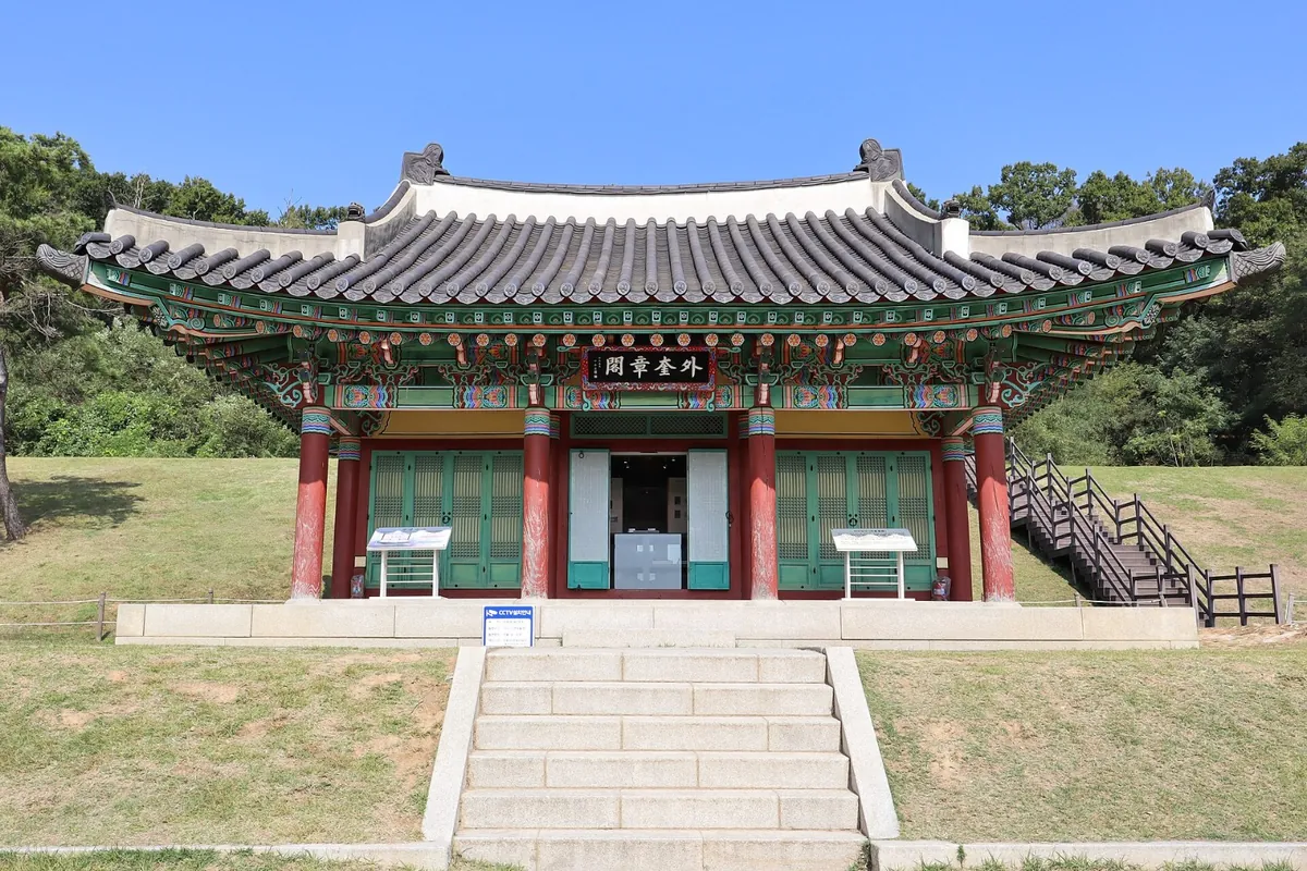 돌계단 위에 선 단청 입힌 외규장각 건물