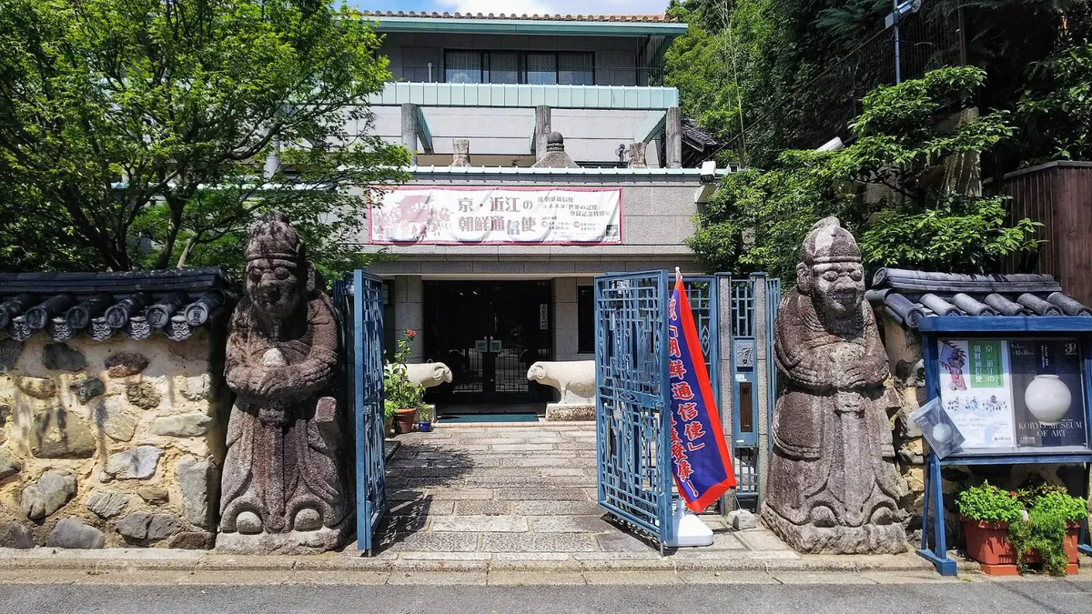 석상 두 기가 문 앞에 선 작은 미술관 입구