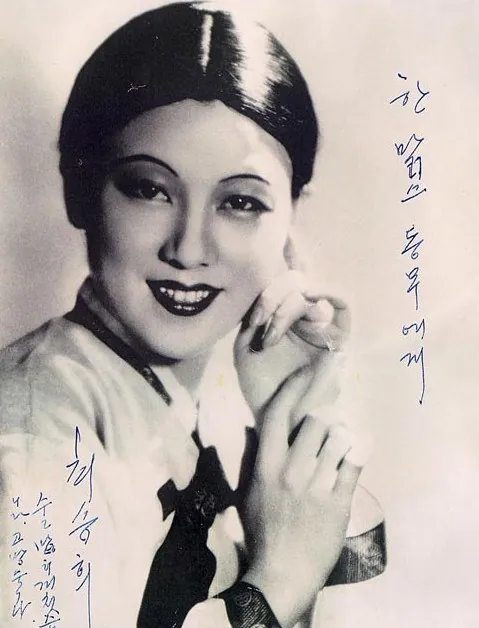 단발머리 여성이 손을 모으고 웃는 흑백 사진 위에 서명이 적혀 있다