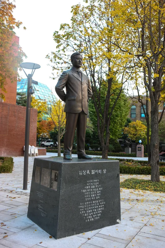단풍 든 공원에 서 있는 김상옥 의사 청동 동상