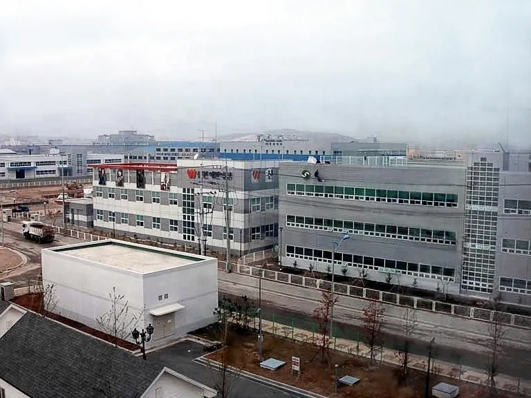 흐린 하늘 아래 낮은 공장 건물들이 줄지어 선 개성공업지구의 모습.