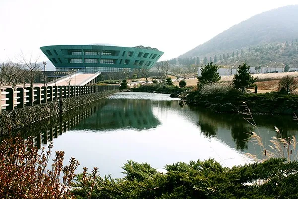 연못 너머 둥근 지붕의 기념관 건물이 보이는 풍경