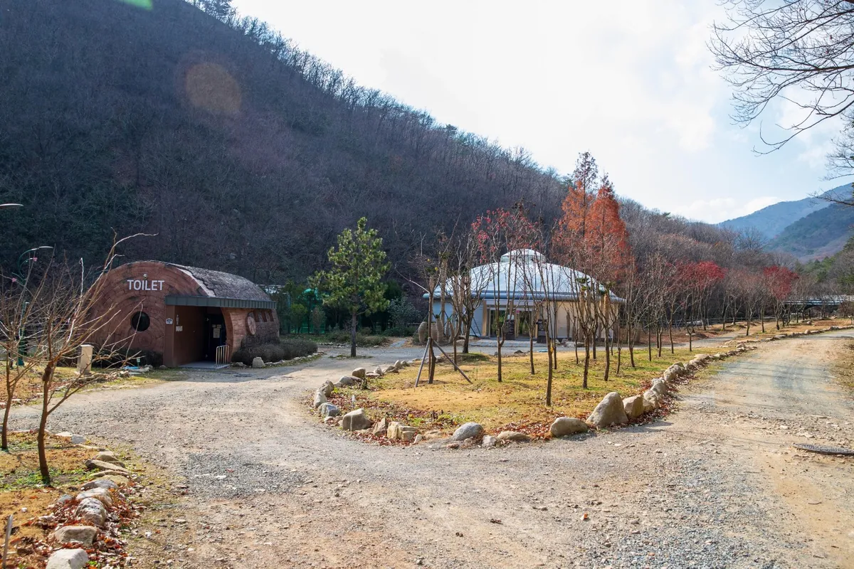 골짜기 안 산비탈 아래로 난 흙길과 작은 건물들